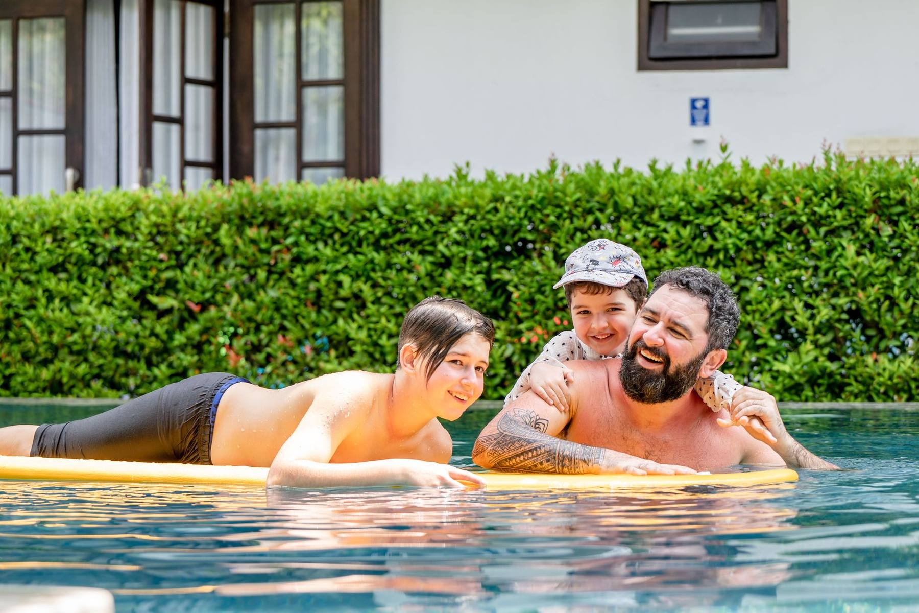 Children playing in a sunlit resort swimming pool